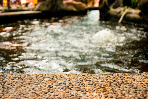 Beautiful pebble pond edge behind a water feature, Pebble stone koi pond edge for product display.