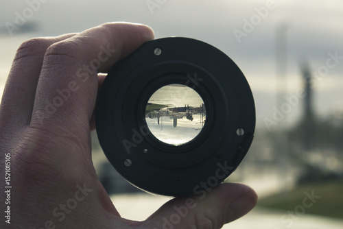 sandy beach with walking people and houses in the background, view through the lens, image inside is inverted