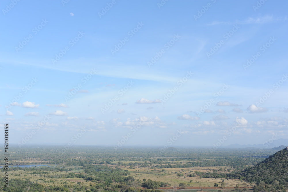 Obraz premium Beautiful natural green landscape from Mihintale mountain peak near Anuradhapura city in Sri Lanka in the afternoon with blue sky