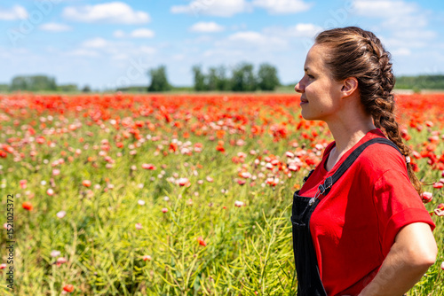 Restoring functional nature with common poppy Papaver rhoeas. Female landowner in a red wild poppies field.