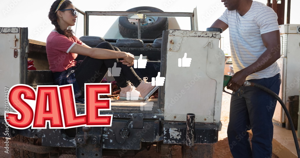 Fototapeta premium Image of sale text and falling icons over diverse couple refueling car