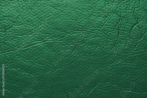 Close up, macro texture of green glossy natural genuine leather, leatherette structure, artifical skin surface with embossed pattern. Background, wallpaper, backdrop