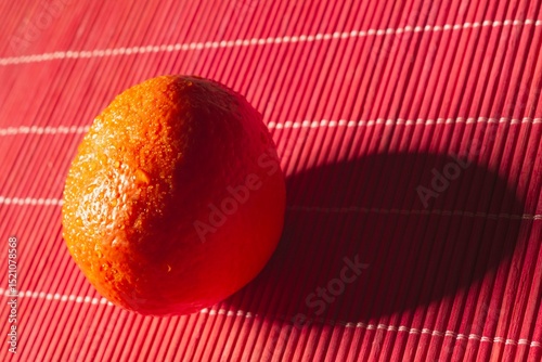 High contrast photograph- oranges with water drops on the peel. Bright highlights on fruit- red background