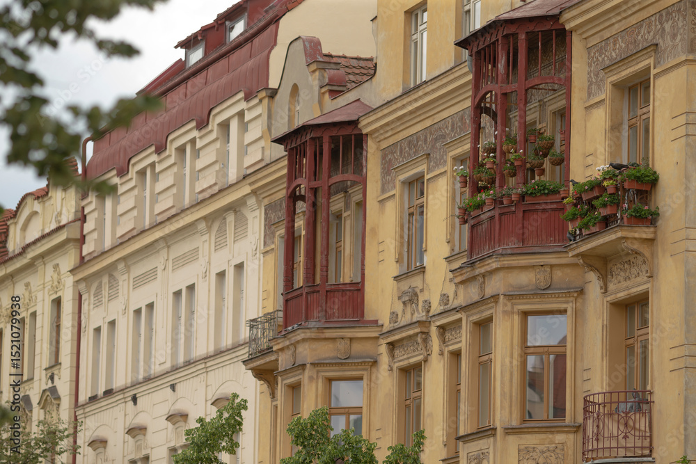 Obraz premium A visually striking facade of historic buildings features decorative balconies with vibrant plants, showcasing the citys rich history and blending oldworld charm with modern design