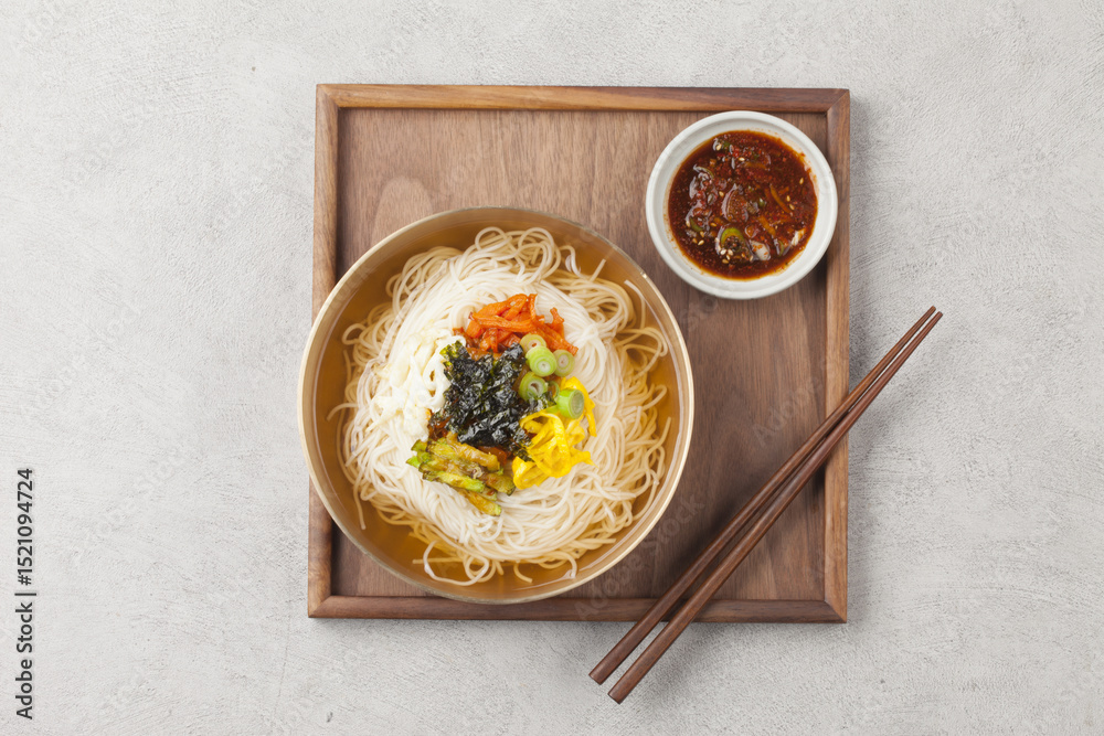 Naklejka premium Janchi Guksu refers to noodles that are mainly eaten on feast days. It is a dish made with noodles in a hot clear soup and various toppings.