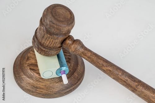 Judge's gavel hits e-cigarette. Smoking ban. Tobacco heating systems. 