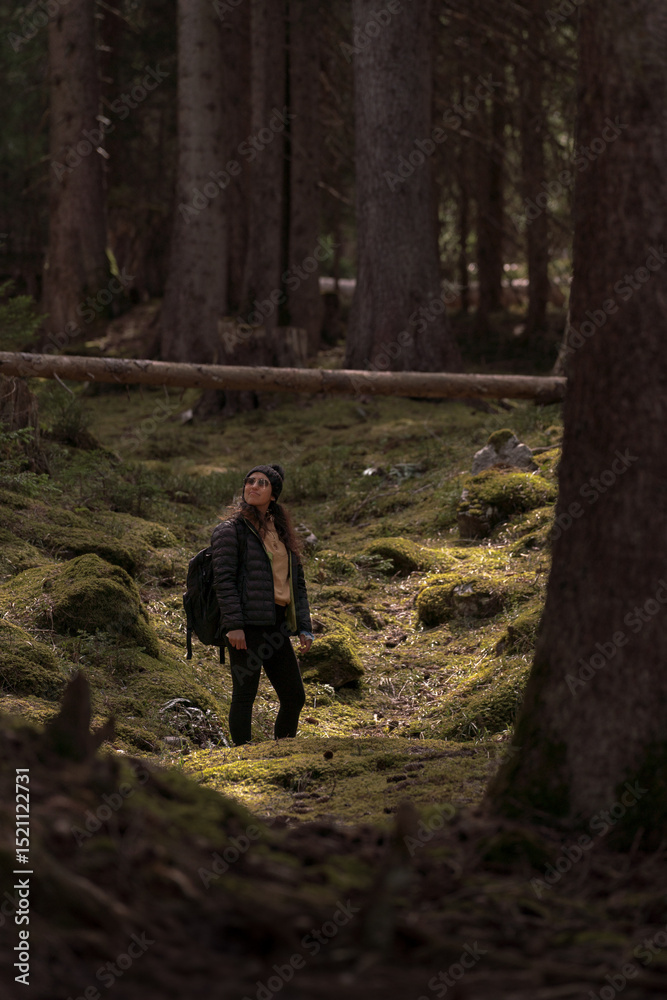 Fototapeta premium Hiker exploring mossy forest path contemplating nature