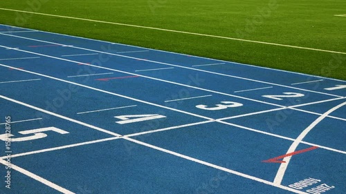 Blue running tracks with white lane markings and numbered starting lines. Perfect for sports, athletics, competitions, fitness, and training themes.