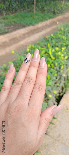 Manicured hand and nails outside in the park