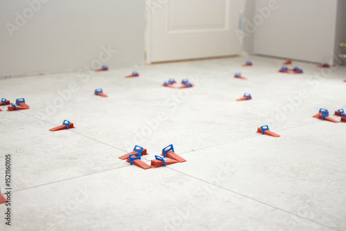Close-up of ceramic tile installation with tile clips and spacers for grouting
