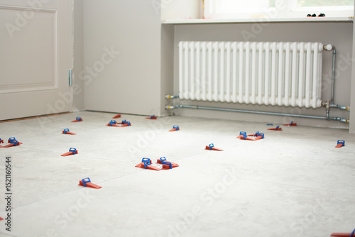 Close-up of ceramic tile installation with tile clips and spacers for grouting