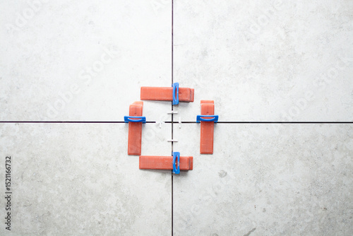 Close-up of ceramic tile installation with tile clips and spacers for grouting