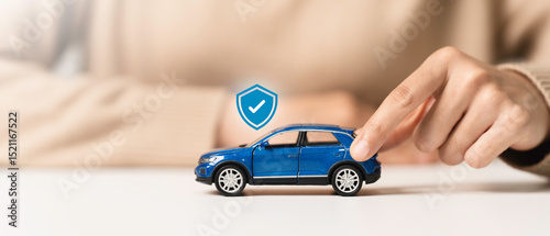 Car insurance, vehicle protection concept. Woman hand holding blue toy car with car insurance icon to coverage covered automobile for financial security.