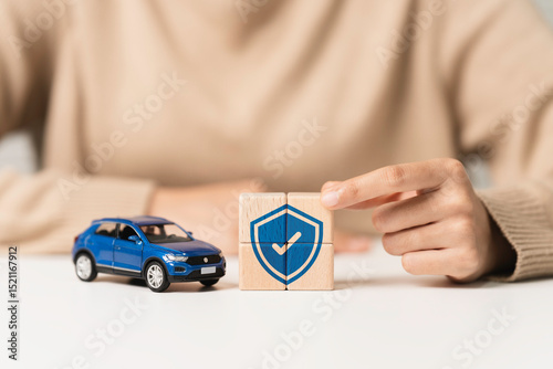Wallpaper Mural Car insurance, vehicle protection concept. Woman holding wooden blocks with insurance icon and blue toy car to coverage covered automobile for financial security. Torontodigital.ca