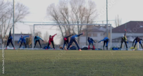 Soccer players do outdoor stretching exercises to improve their fitness and performance in the sport