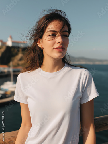 Plain White T-Shirt Worn By A Young Woman Outdoors With Ocean Background On A Sunny Day