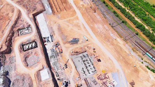 Aerial view of a cement plant construction site with visible foundations, machinery, and engineering structures.