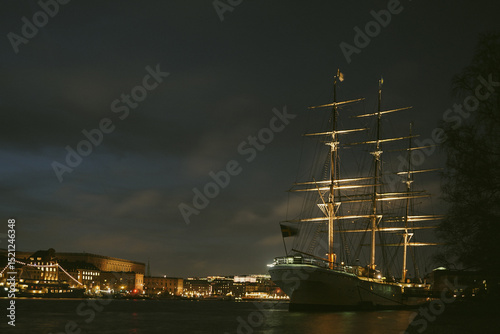 A ship at anchor with a city in the background