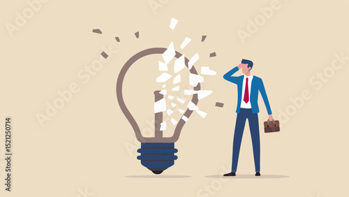 Man in suit looking at shattered light bulb representing a broken idea or creative block concept failure