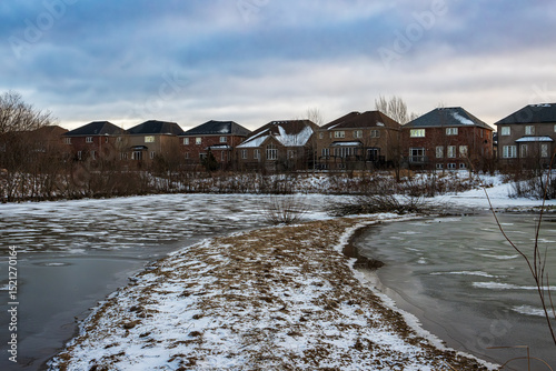 Frozen pond in snowy landscape scene during winter in Ancsater, Hamilton, Ontario, Canada.