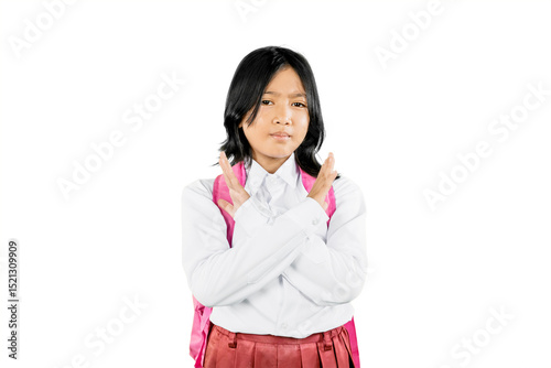 Asian schoolgirl making X sign with arms, expressing refusal or protest, wearing uniform and backpack on white background