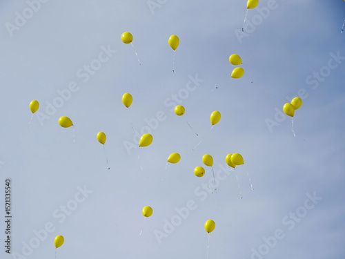 Yellow balloons fly in the sky