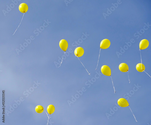 Yellow balloons fly in the sky