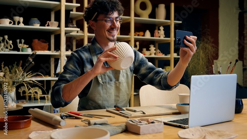 Small business owner Caucasian man guy artist potter salesman blogger influencer mobile phone photo male sculptor craft sale online blog ceramics sell online social media handmade in pottery workshop