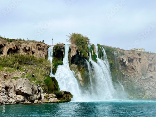 Duden Waterfalls in Antalya, Turkey, cascading into the turquoise blue waters of the Mediterranean Sea. Travel, summer vacation, Mediterranean coast, nature, scenic spot, Turkish Riviera. 