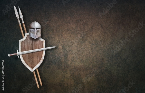 knight's helmet sword wooden shield and two spears on grunge background