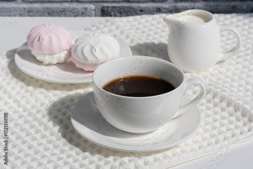 Enjoying coffee and sweets on a sunny morning with meringues and cream