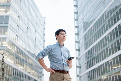 Wallpaper Mural asian businessman using smart phone out of office building Torontodigital.ca