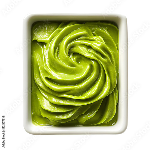 A close-up view of vibrant green matcha paste swirled in a white bowl, ideal for culinary presentations and food styling.