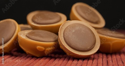Chocolate candies rotates on black background, close-up shot video