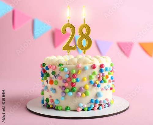 Photography Yummy cake with burning number shaped candles on pink background