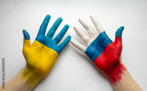 Painted human hands decorated with flags of Russia and Ukraine stand out on a white background. The concept of peace, friendship and creation