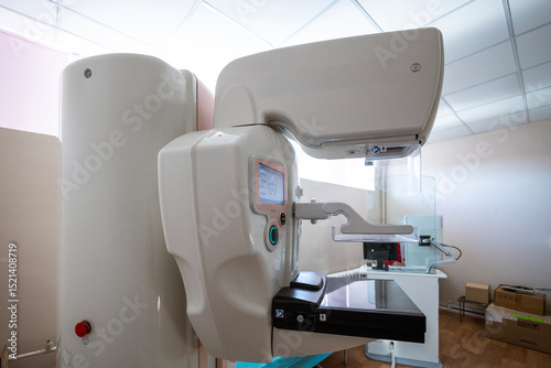 A modern mammography machine with dual interactive screens stands in a clean medical room, ready for diagnostic imaging