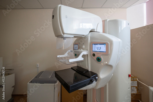 A modern mammography machine with dual interactive screens stands in a clean medical room, ready for diagnostic imaging