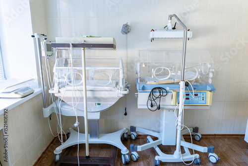 A clean, empty hospital incubator room features two transparent infant incubators.