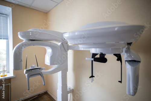 A modern X-Mind Prime panoramic dental X-ray machine, an orthopantomograph, displays a digital dental image on its monitor in a clinic setting.