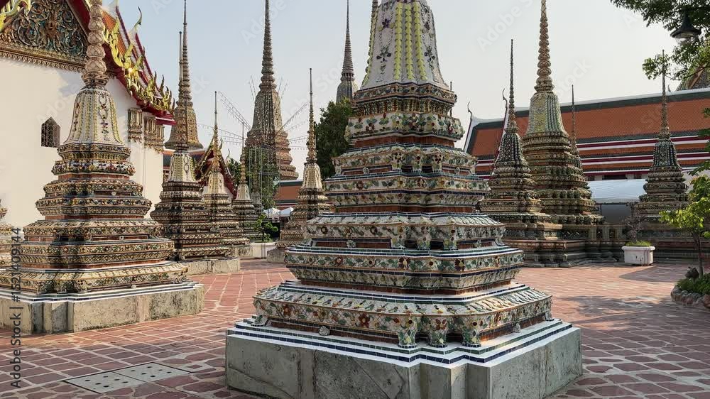 Ornate stupas and temple architecture in Wat Pho, Bangkok, Thailand.  Intricate details and vibrant colors showcase rich cultural heritage. A peaceful scene of religious significance.