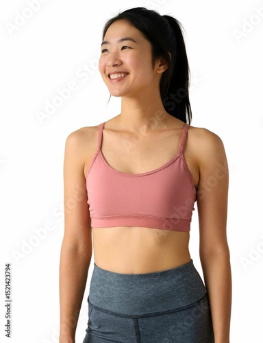 A smiling woman with long black hair in a ponytail, wearing a pink sports bra and gray leggings, against a white background.