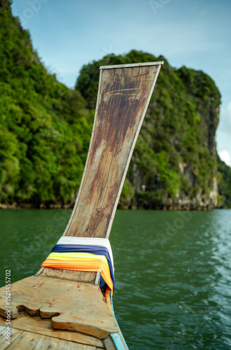 Fototapeta Naklejka Na Ścianę i Meble -  Thai boat with a long wooden pole sticking out of it against the backdrop of islands