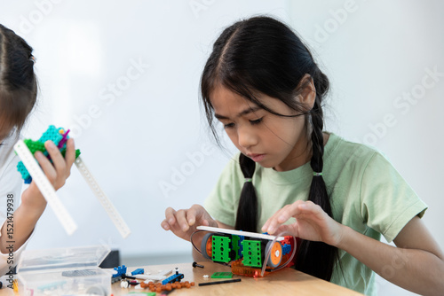 A young girl intently builds a colorful STEM or robotics model, focusing on her educational project, fostering creativity and critical thinking skills