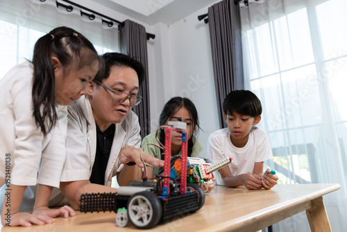 Diverse group of children learning about robotics with a teacher in a STEM class. Hands-on science and technology education in a fun and engaging classroom environment