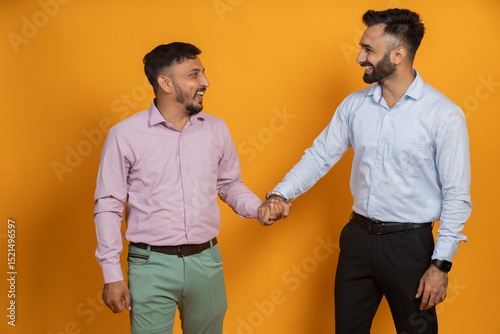 Indian men in causal wear shaking hands with happy expression
