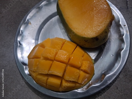 Freshly sliced ripe mango with juicy golden cubes on rustic wooden table, showcasing tropical fruit’s vibrant color and delicious texture.
