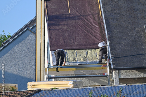 ouvrier couvreur sur un toit d'habitation