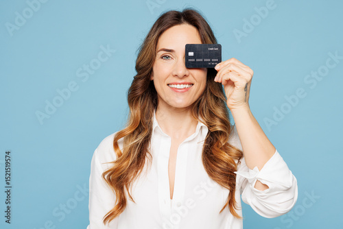 Young successful employee business woman corporate lawyer wear shirt classic formal clothes work in office hold cover eye with mock up of credit bank card isolated on blue background studio portrait.