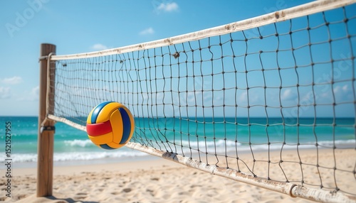 Beach volleyball net with colorful ball on sandy shore